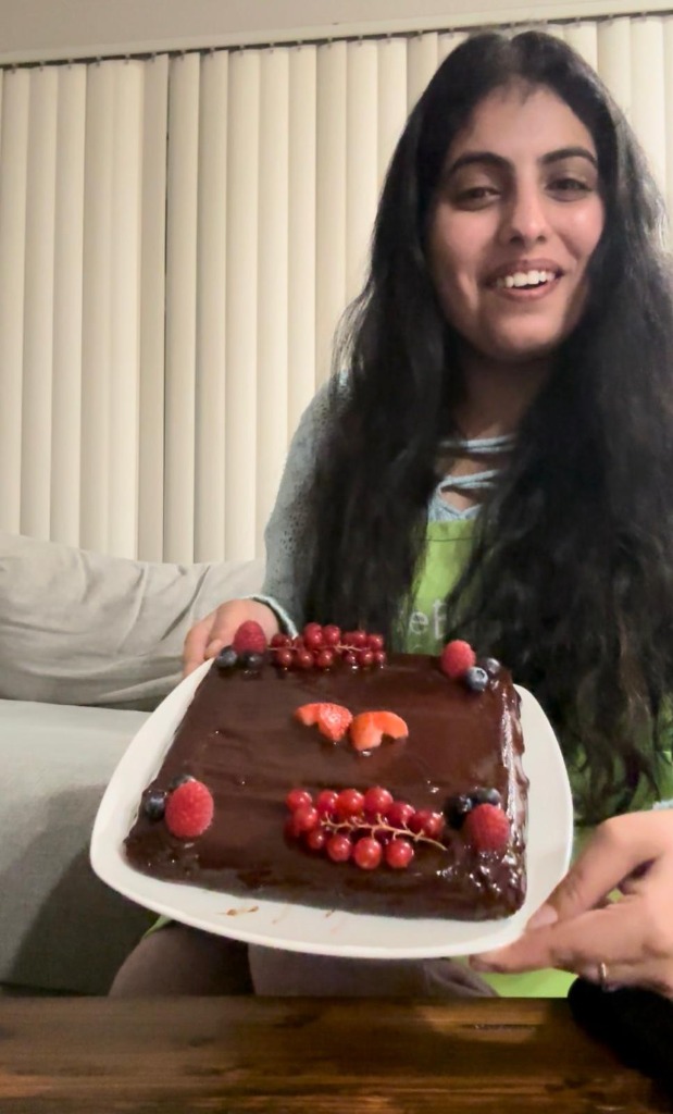 Sampada smiling with a home-baked cake